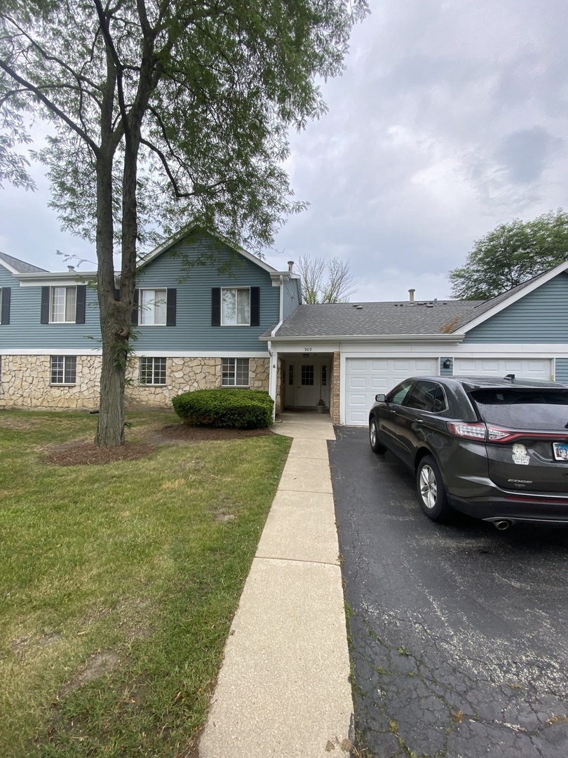 309 Memory Lane, Unit 1 Westmont, IL 60559 - Photo 1 of 23 a view of a car parked in front of a house