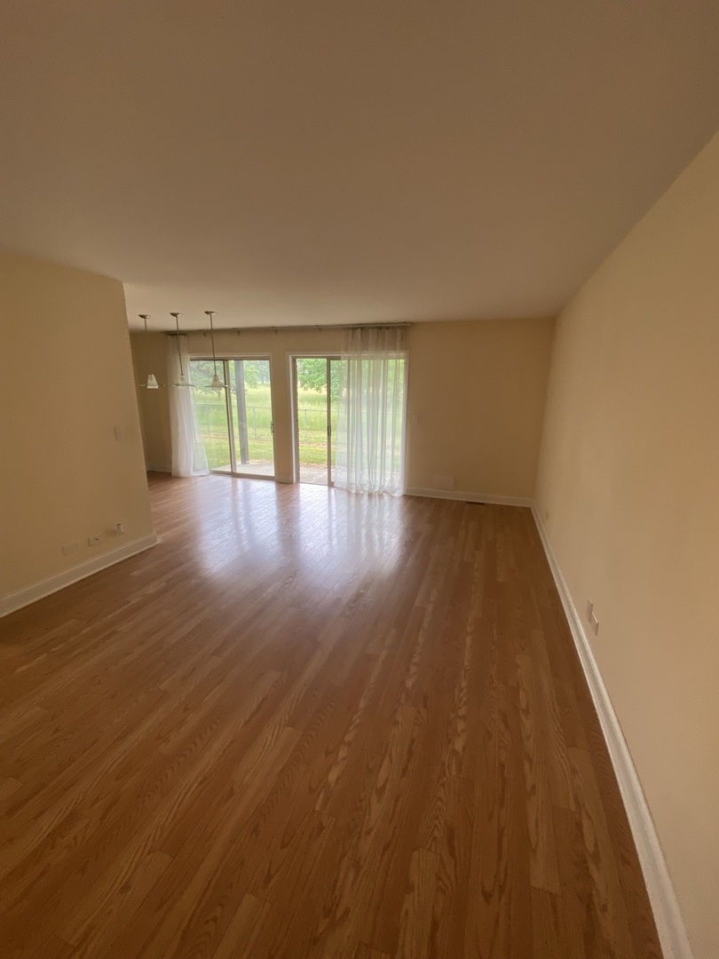 309 Memory Lane, Unit 1 Westmont, IL 60559 - Photo 14 of 23 an empty room with wooden floor and windows