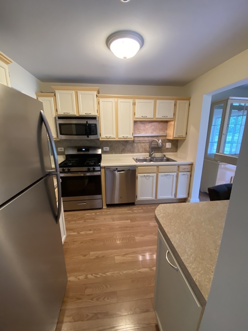 309 Memory Lane, Unit 1 Westmont, IL 60559 - Photo 2 of 23 a kitchen with stainless steel appliances granite countertop a refrigerator a stove a sink dishwasher and a refrigerator