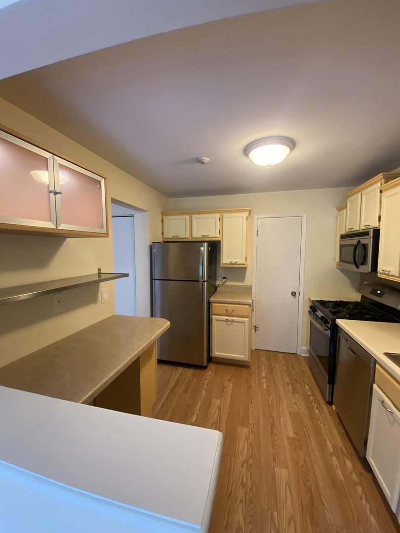 309 Memory Lane, Unit 1 Westmont, IL 60559 - Photo 3 of 23 a kitchen with refrigerator cabinets and wooden floor