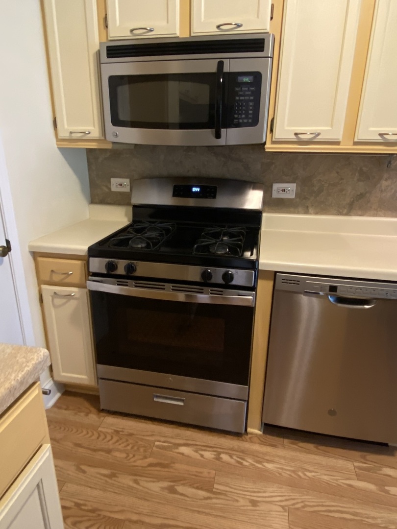 309 Memory Lane, Unit 1 Westmont, IL 60559 - Photo 5 of 23 a kitchen with granite countertop a stove and a microwave