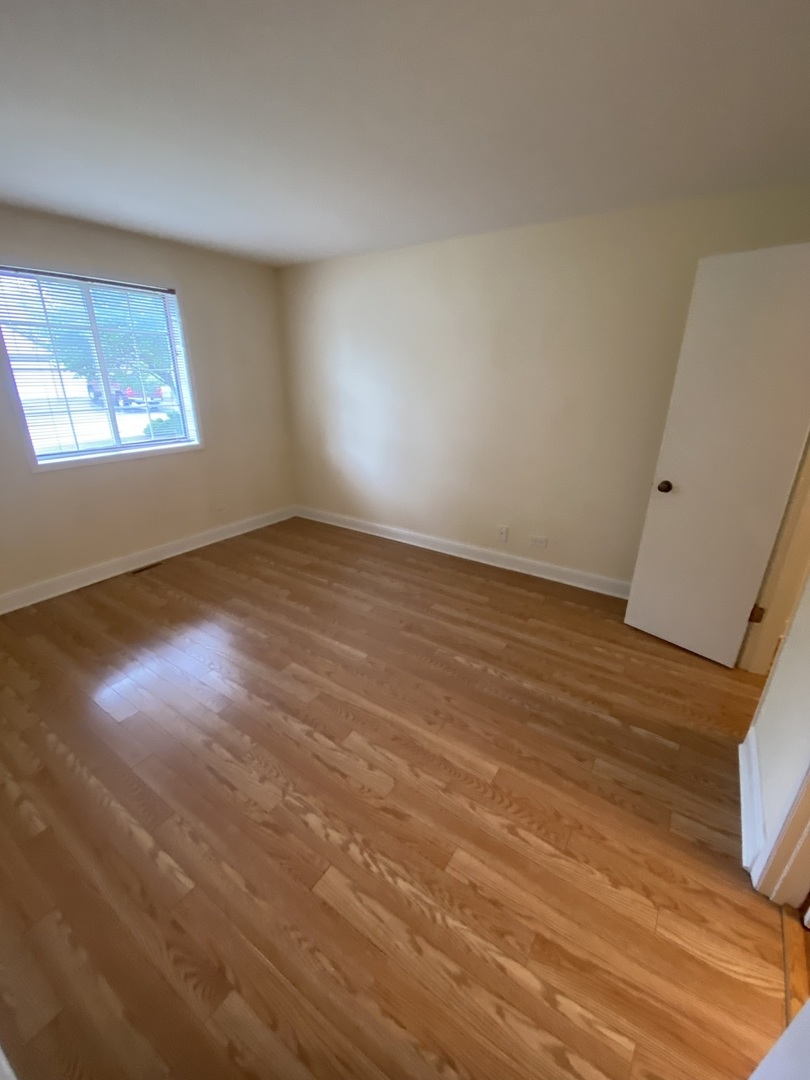 309 Memory Lane, Unit 1 Westmont, IL 60559 - Photo 10 of 23 an empty room with wooden floor and windows