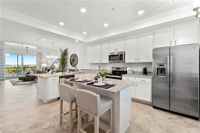 a kitchen with a sink a counter top space stainless steel appliances and cabinets