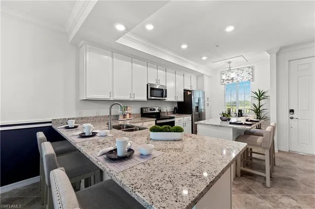 a kitchen with stainless steel appliances granite countertop a stove top oven a sink a table and chairs