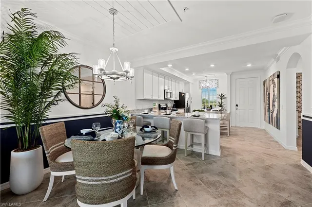 a living room with furniture a chandelier and a dining table