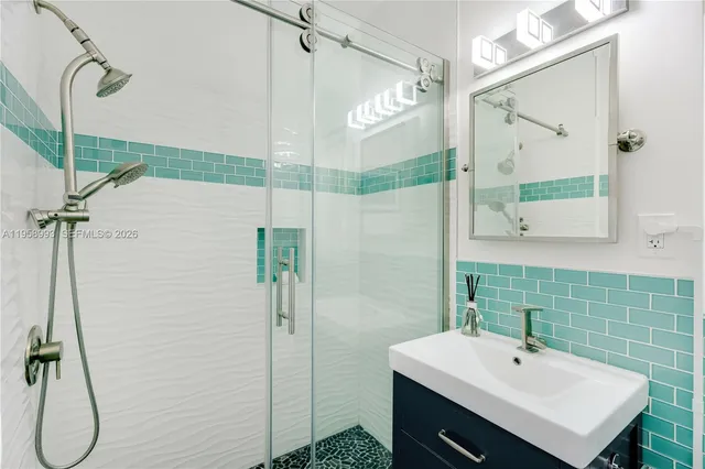 a bathroom with a sink mirror and shower