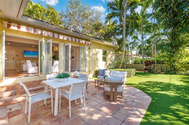 a view of a patio with a table and chairs and potted plants