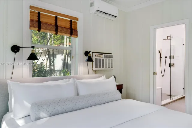 a bedroom with a large bed and a chandelier