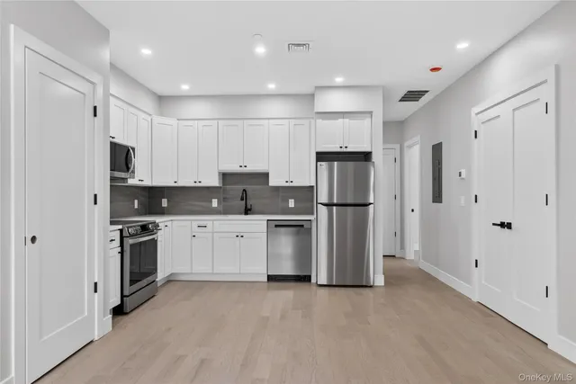 a kitchen with stainless steel appliances granite countertop a refrigerator and a stove top oven