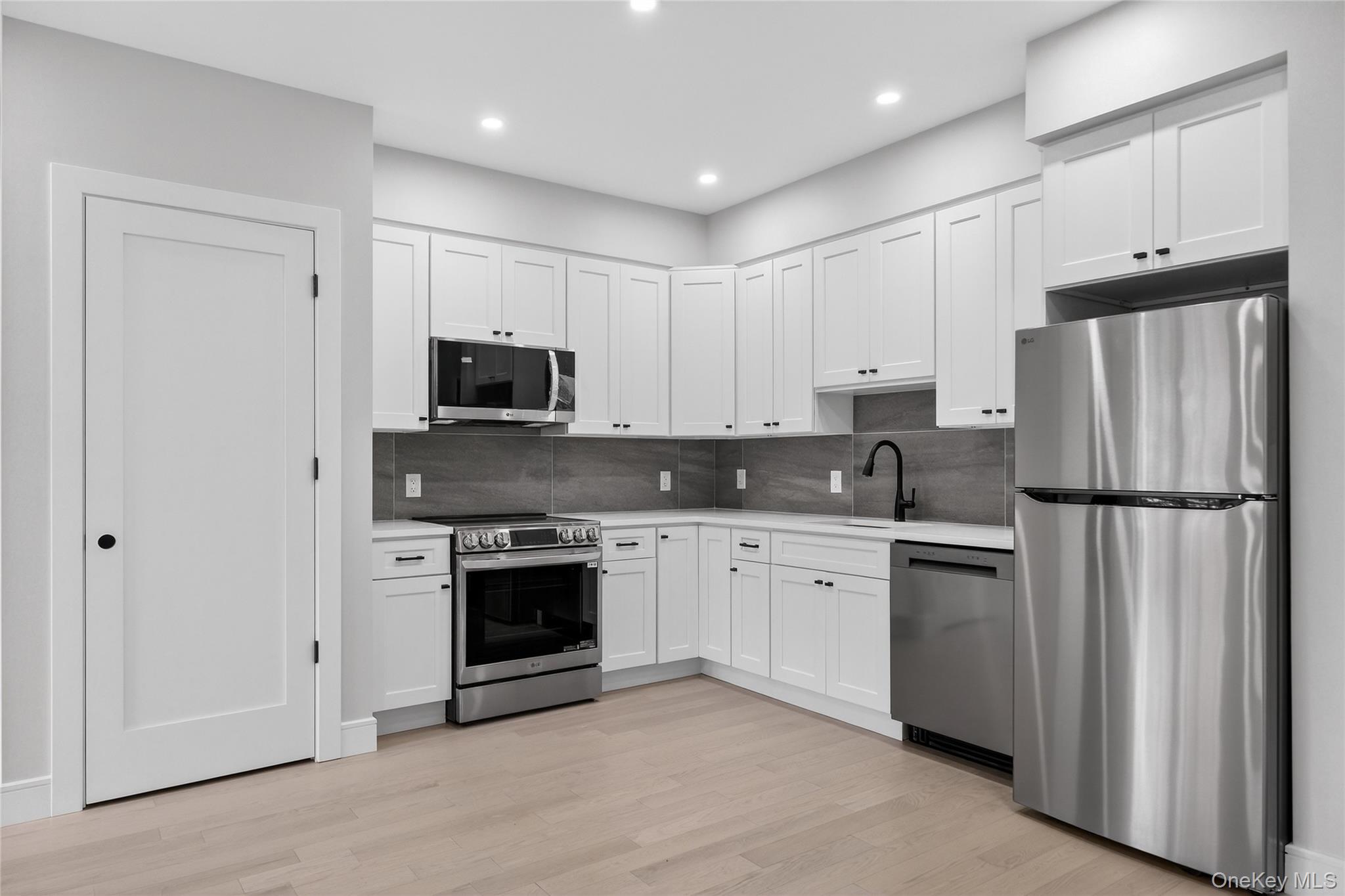 10 Market Street, Unit F Wappingers Falls, NY 12590 - Photo 3 of 14 a kitchen with granite countertop white cabinets and stainless steel appliances