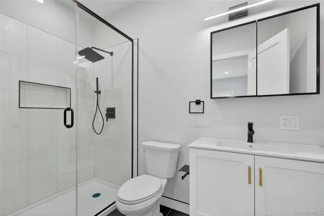 a bathroom with a shower sink vanity and toilet
