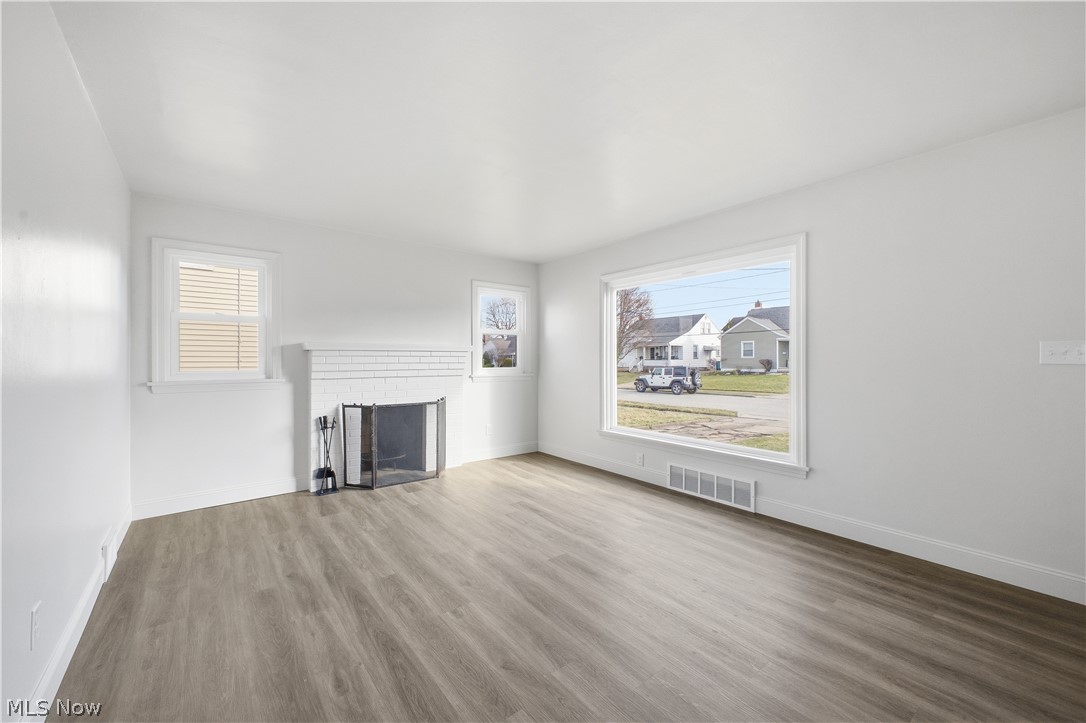 227 Wilson Street Struthers, OH 44471 - Photo 5 of 44 Unfurnished living room featuring wood finished floors, a fireplace, and healthy amount of natural light