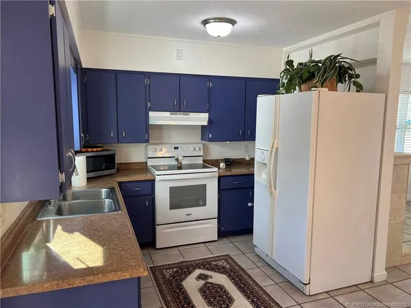 a kitchen with a refrigerator and a stove top oven