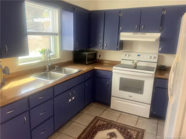 a kitchen with a sink a stove and cabinets