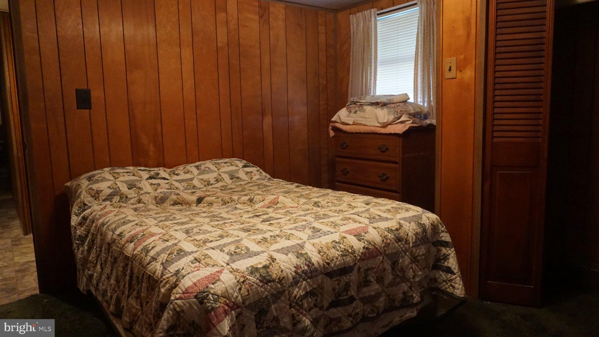 107 Country Lane Buena, NJ 08310 - Photo 6 of 6 a bed sitting in a bedroom next to a wooden door