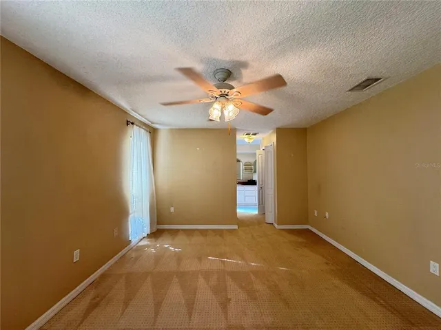 a view of an empty room with a ceiling fan