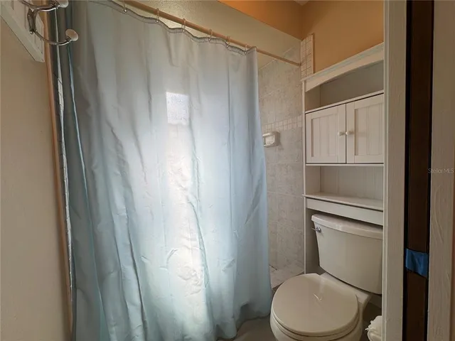 a bathroom with a toilet and a shower