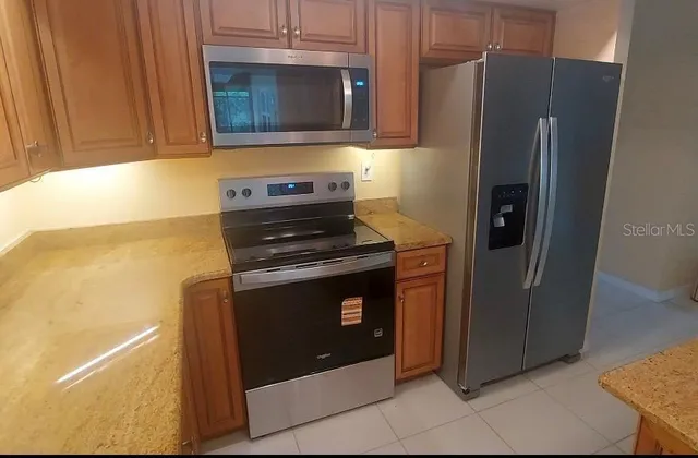 a kitchen with stainless steel appliances granite countertop a refrigerator and a stove top oven
