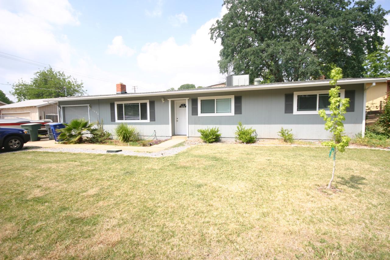 1030 Harpole Road Redding, CA 96002 - Photo 1 of 3 a front view of a house with a yard and potted plants