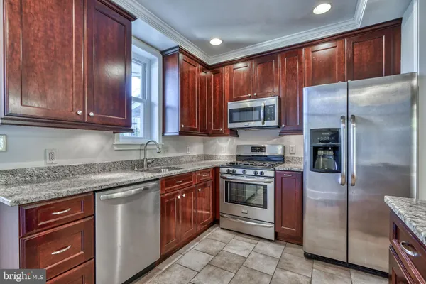 a kitchen with stainless steel appliances granite countertop a refrigerator and a sink