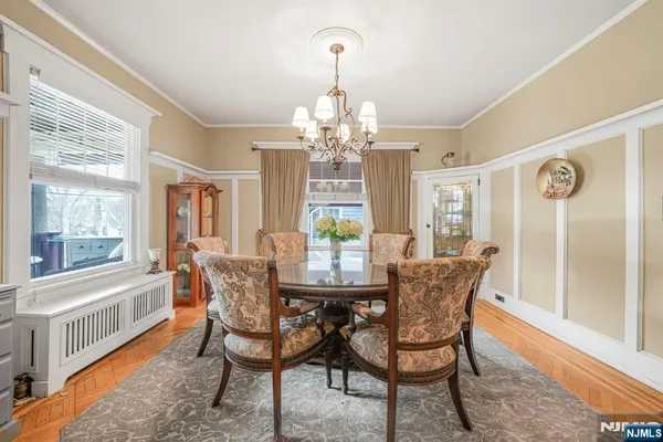 a dining room with furniture a chandelier and wooden floor