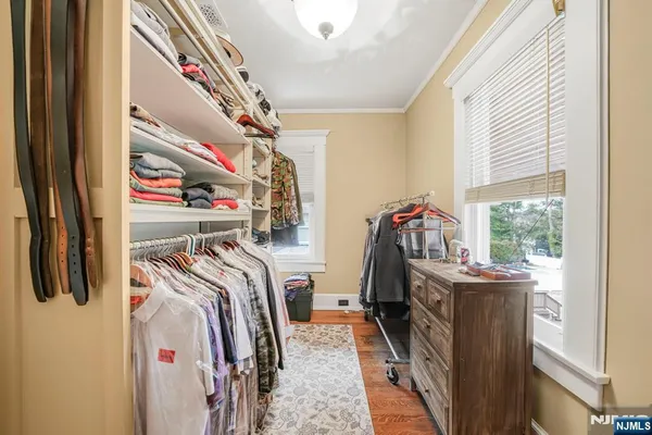 a view of walk in closet with clothes and shoes
