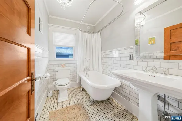 a bathroom with a sink toilet a mirror and bathtub
