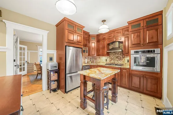 a kitchen with stainless steel appliances granite countertop a refrigerator and a stove top oven