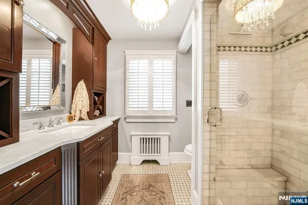a bathroom with a double vanity sink a mirror and next to a window
