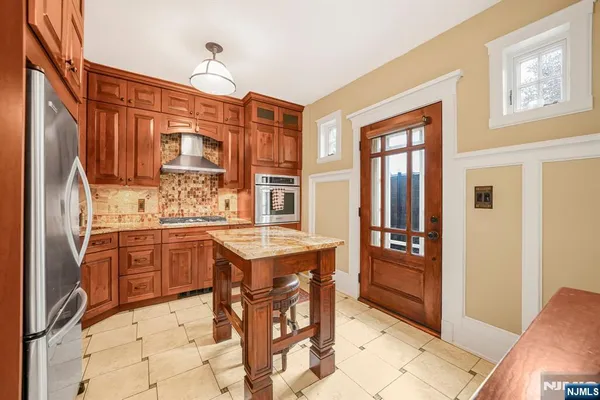 a kitchen with stainless steel appliances granite countertop a refrigerator and stove