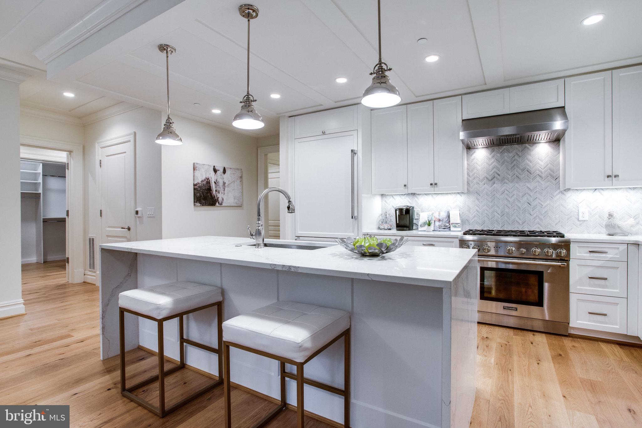 a kitchen with kitchen island a stove a sink a oven and a wooden floor