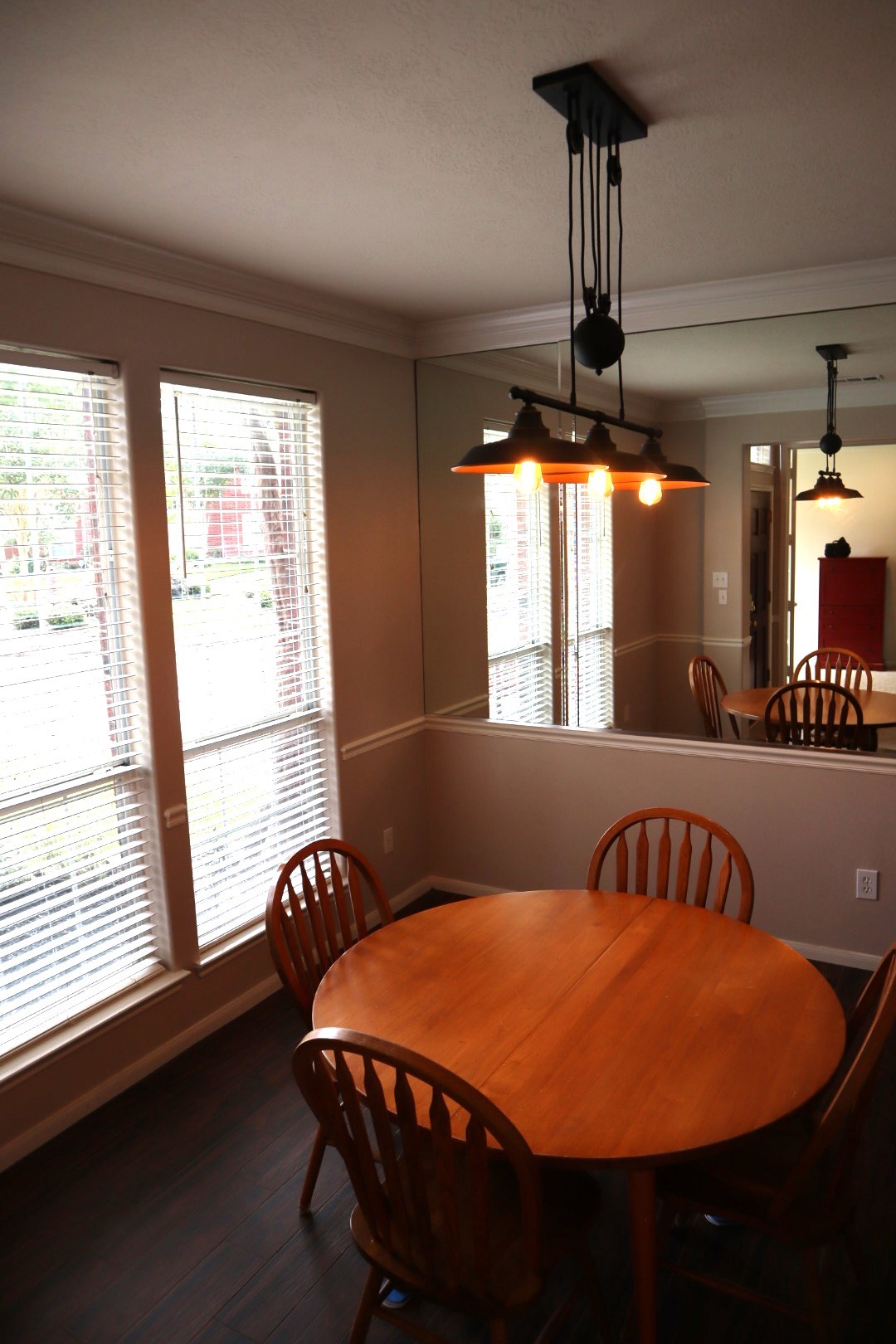 19114 Emory Trail Spring, TX 77388 - Photo 6 of 32 This cozy dining area features large windows for natural light and a stylish pendant light. The wall mirror enhances the sense of space, complementing the warm, inviting atmosphere.