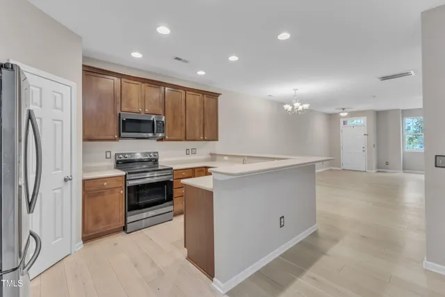a kitchen with kitchen island a sink stainless steel appliances and cabinets
