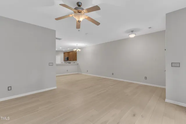 an empty room with projector and a ceiling fan