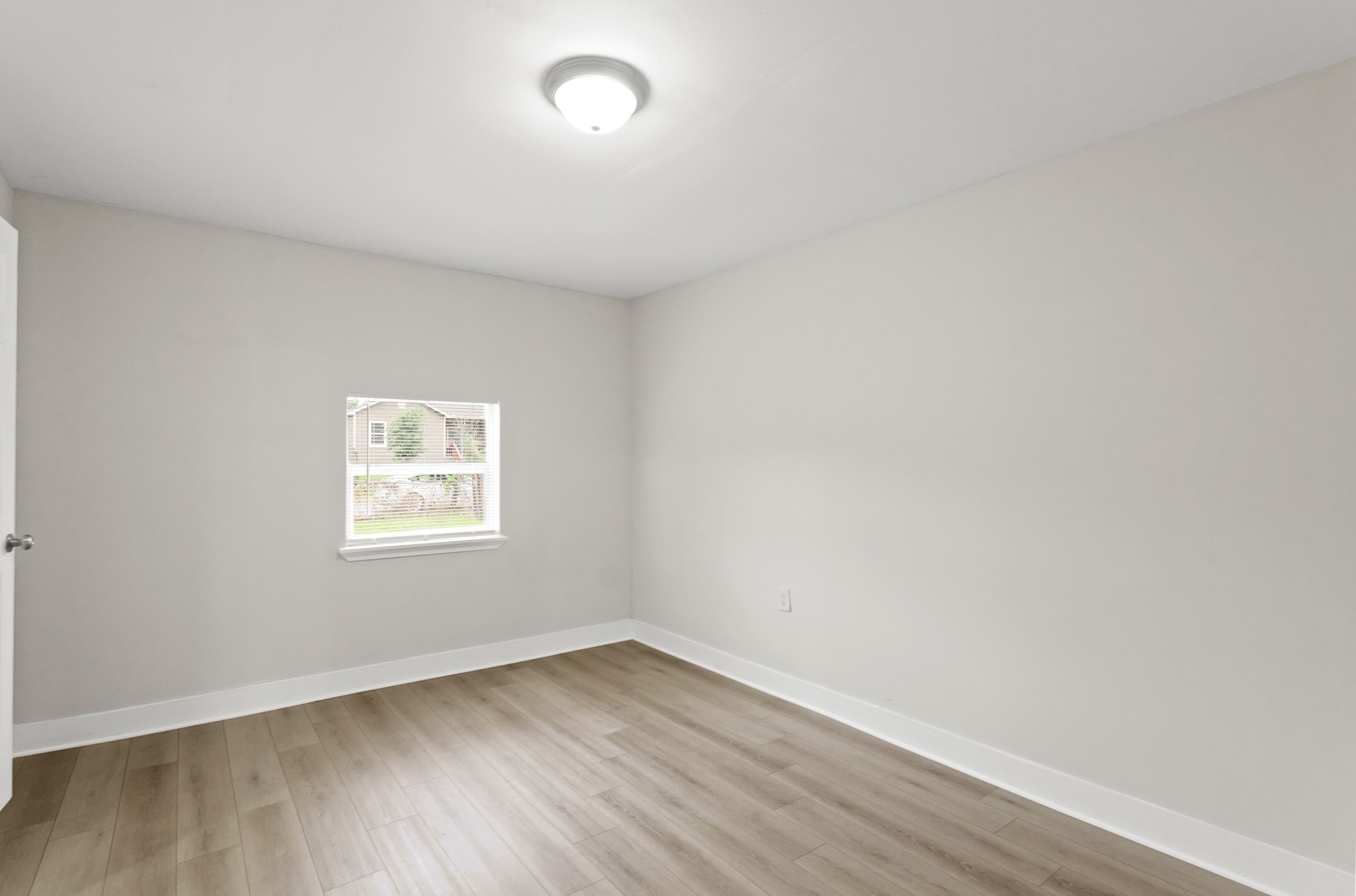 9133 Woodlyn Road Houston, TX 77078 - Photo 2 of 16 an empty room with wooden floor and windows