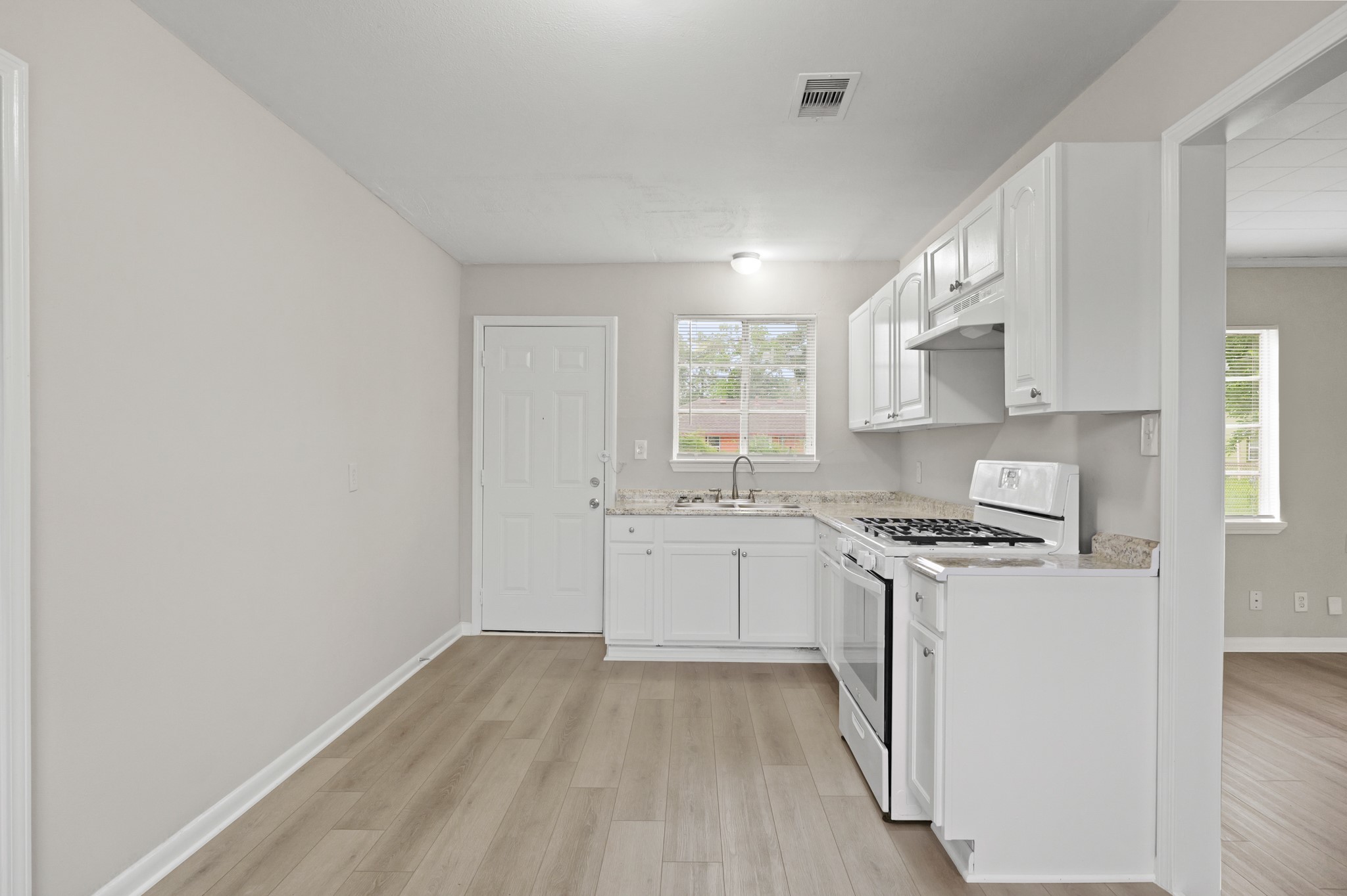 9133 Woodlyn Road Houston, TX 77078 - Photo 4 of 16 a kitchen with granite countertop white cabinets and white appliances