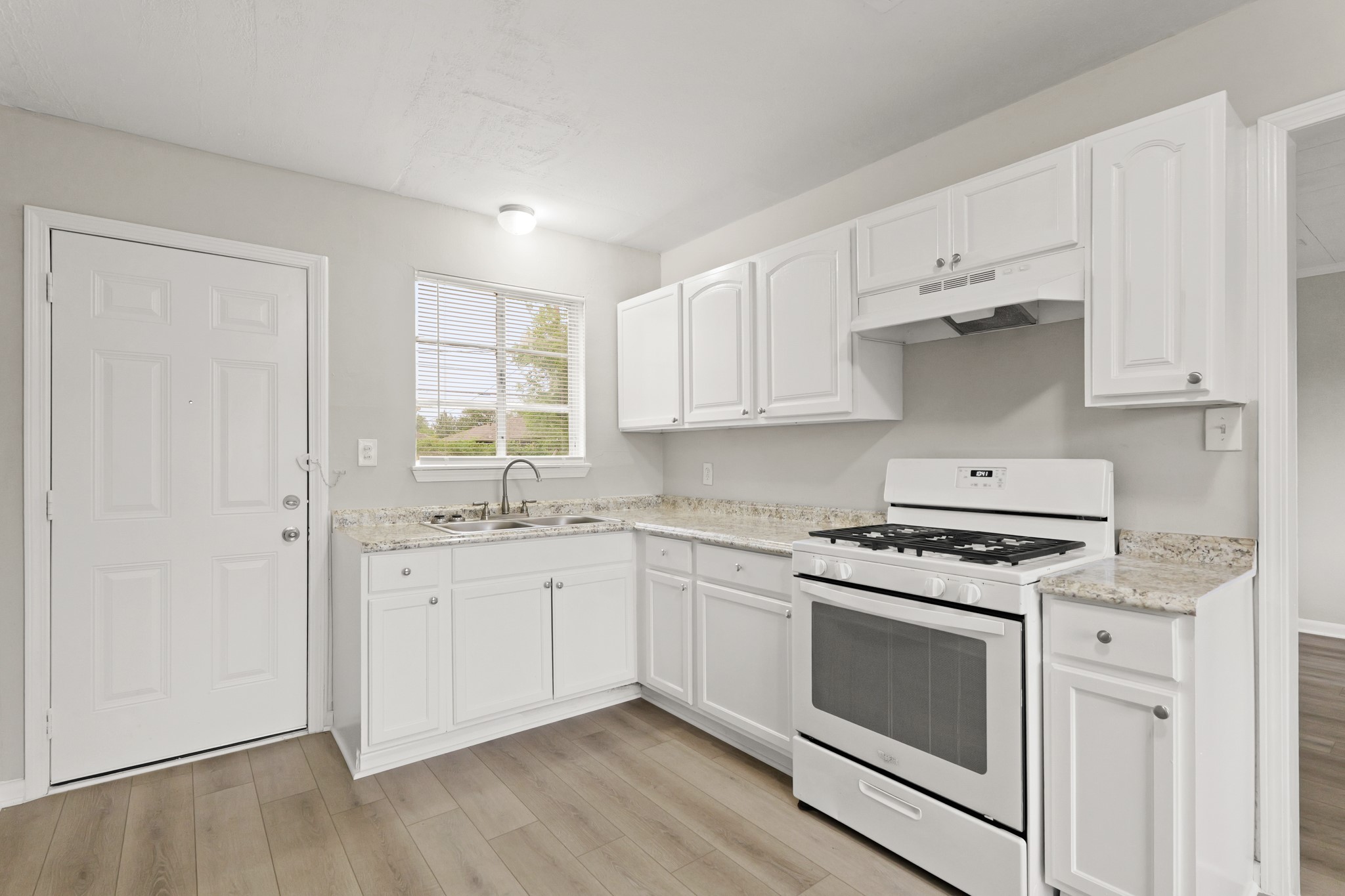 9133 Woodlyn Road Houston, TX 77078 - Photo 5 of 16 a kitchen with granite countertop white cabinets and white appliances