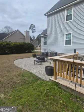 a view of a house with backyard and sitting area