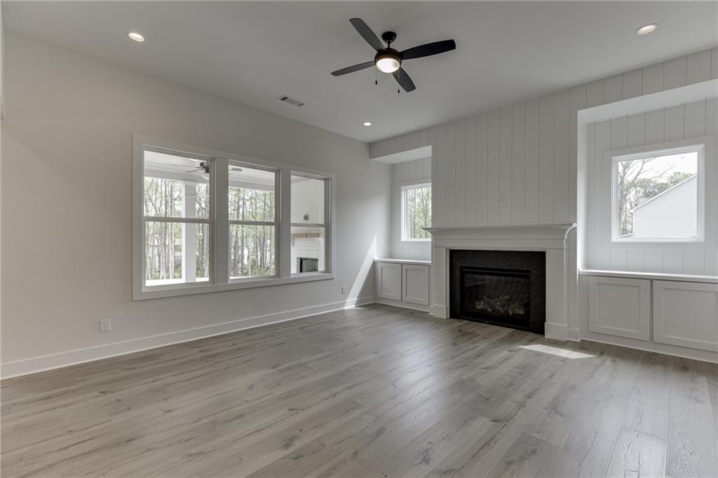 5410 Settingdown Road Cumming, GA 30041 - Photo 14 of 47 a view of empty room with wooden floor and fireplace
