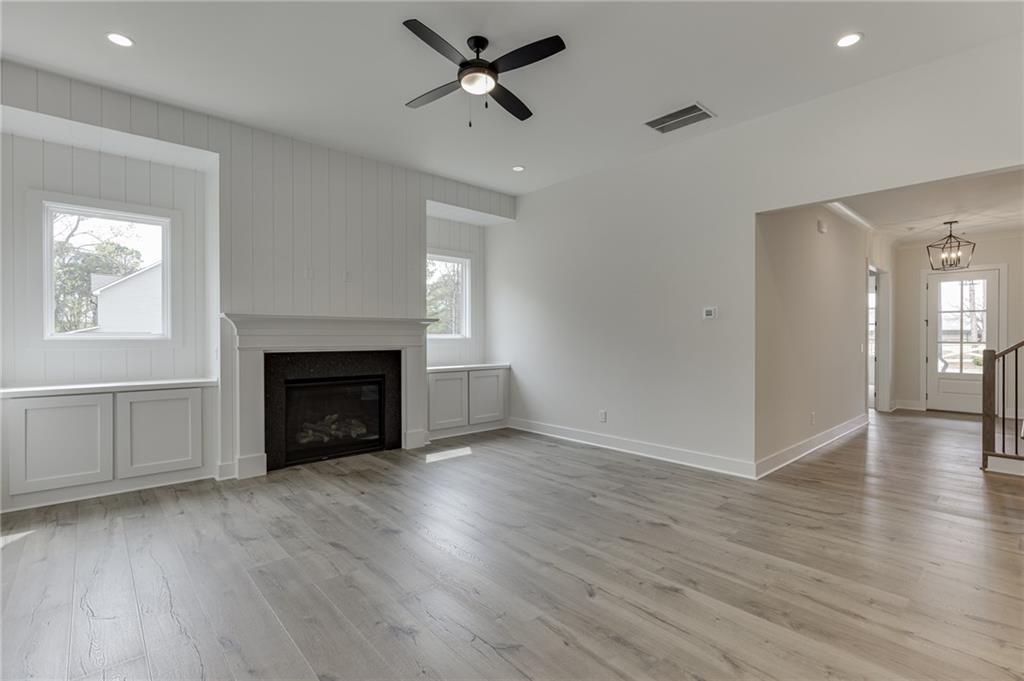 5410 Settingdown Road Cumming, GA 30041 - Photo 16 of 47 an empty room with wooden floor a fireplace and windows