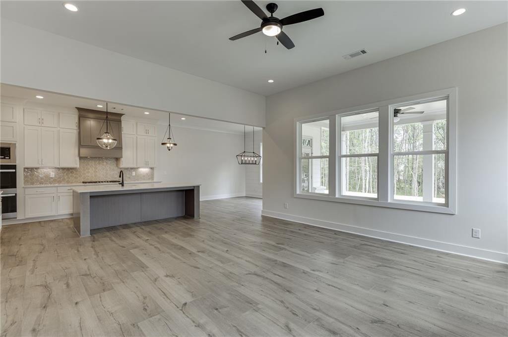 5410 Settingdown Road Cumming, GA 30041 - Photo 17 of 47 a large kitchen with stainless steel appliances a large counter top a sink and a window
