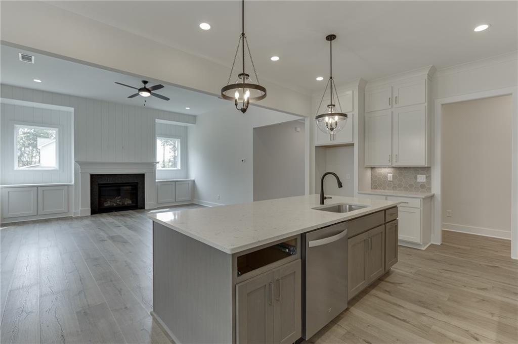 5410 Settingdown Road Cumming, GA 30041 - Photo 22 of 47 a kitchen with a sink chandelier and wooden floor