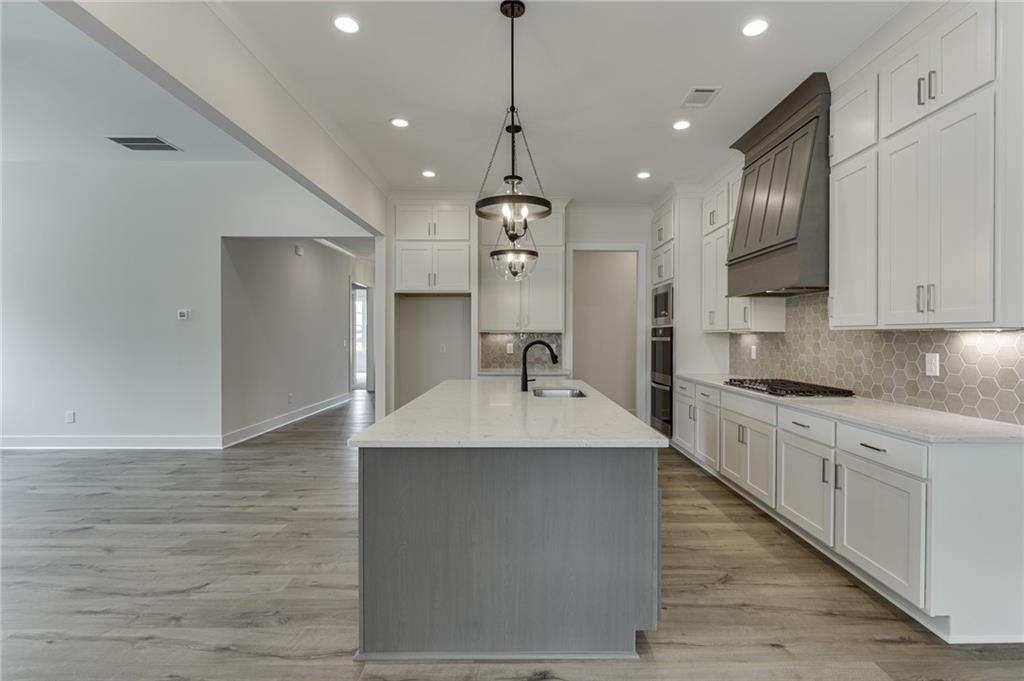5410 Settingdown Road Cumming, GA 30041 - Photo 23 of 47 a large kitchen with stainless steel appliances granite countertop a sink dishwasher a refrigerator and a stove