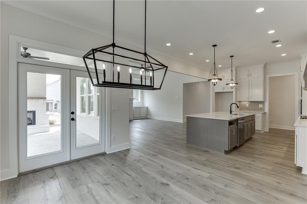 5410 Settingdown Road Cumming, GA 30041 - Photo 26 of 47 a kitchen with stainless steel appliances granite countertop a refrigerator a sink dishwasher and a stove with wooden floor