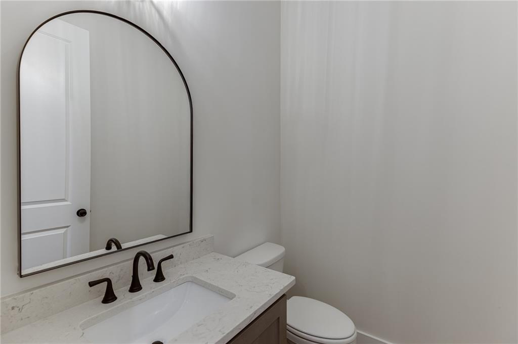 5410 Settingdown Road Cumming, GA 30041 - Photo 27 of 47 a bathroom with a sink a toilet and a mirror