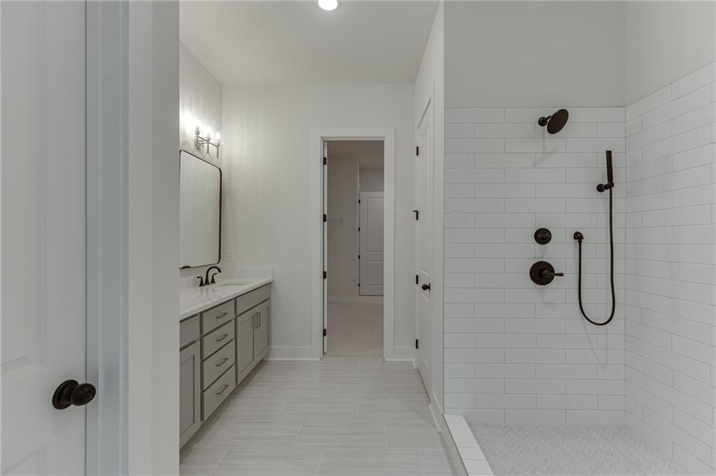 5410 Settingdown Road Cumming, GA 30041 - Photo 32 of 47 a bathroom with a double vanity sink a shower and mirror