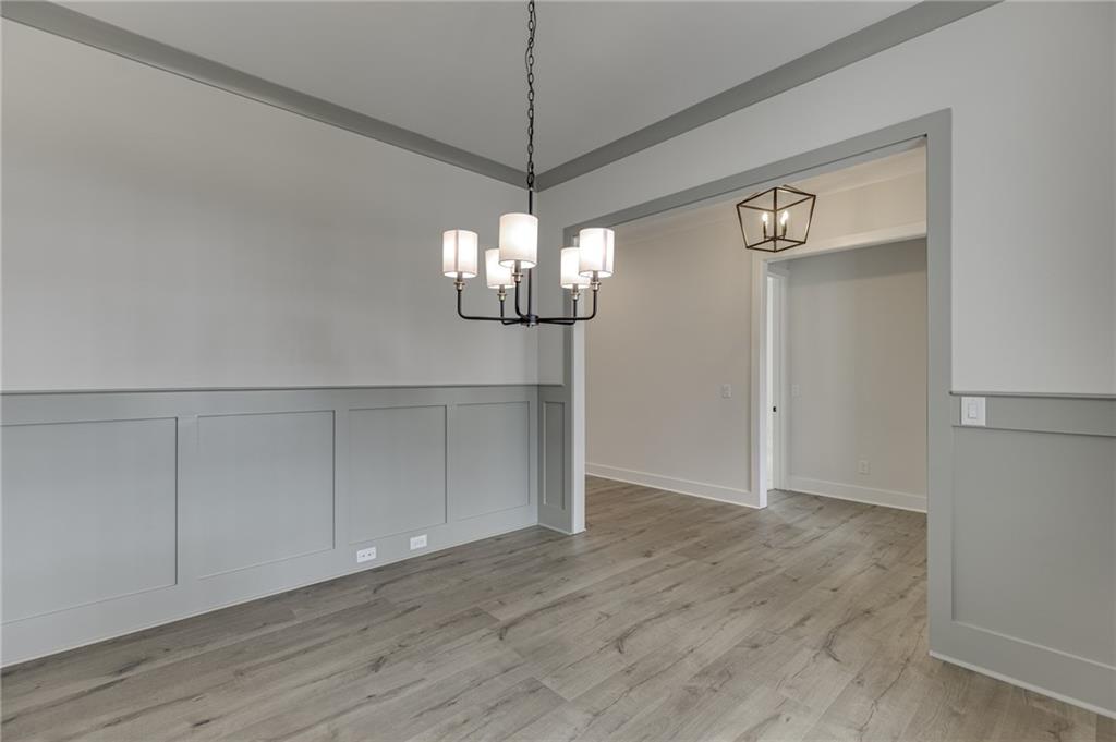 5410 Settingdown Road Cumming, GA 30041 - Photo 7 of 47 a view of an empty room with wooden floor and chandelier