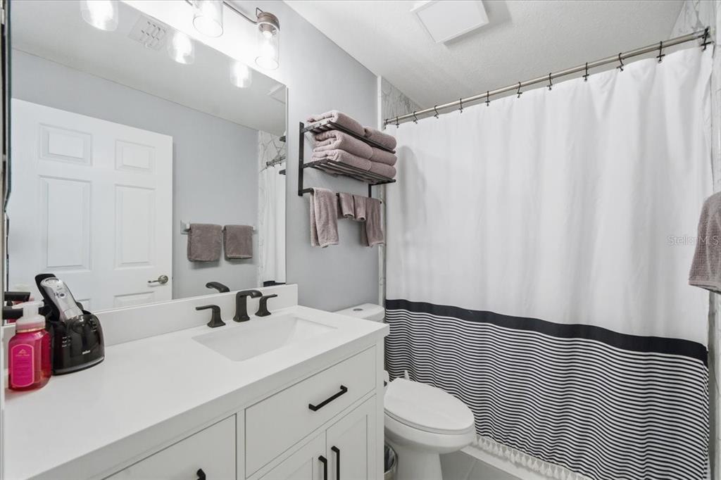 18641 Rolling Hills Loop Hudson, FL 34667 - Photo 29 of 44 a bathroom with a sink a toilet and shower curtain