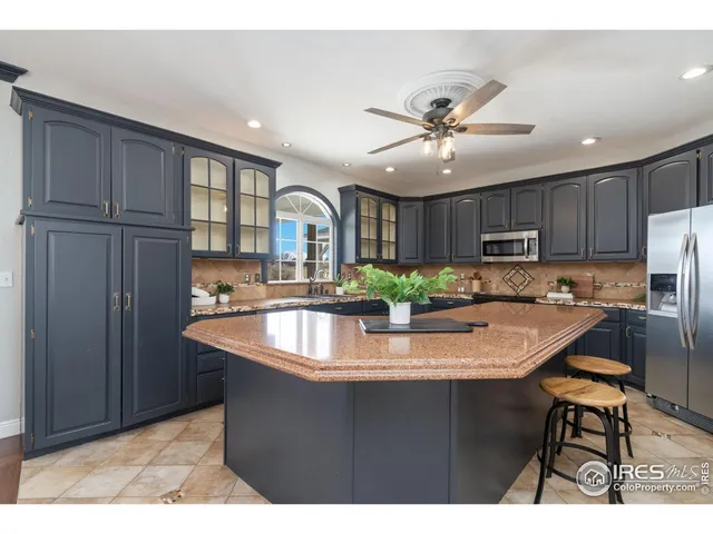 a kitchen with stainless steel appliances granite countertop a sink a stove and a refrigerator