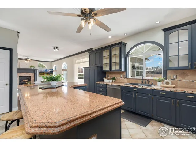 a kitchen with stainless steel appliances granite countertop a stove a sink dishwasher a dining table and chairs with wooden floor